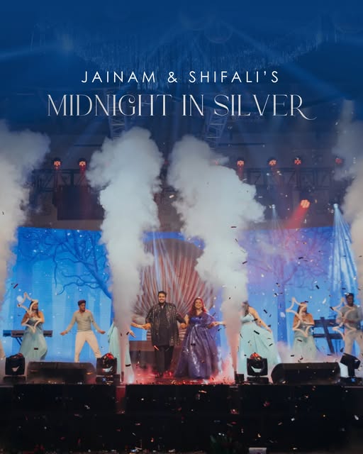A couple on a smoke-filled stage during an evening celebration