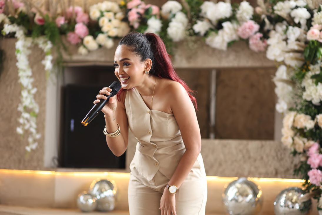 Reetu Jain speaking with a microphone at a Wedventure session
